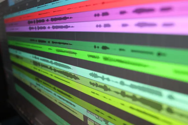 Pantalla de ordenador con un editor de audio mostrando ondas de sonido en varias pistas