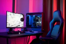 Escritorio gamer con monitor, torre de PC y silla ergonómica