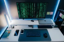 Varios móviles conectados por cable USB a un portátil sobre una mesa de trabajo