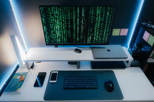 Varios móviles conectados por cable USB a un portátil sobre una mesa de trabajo