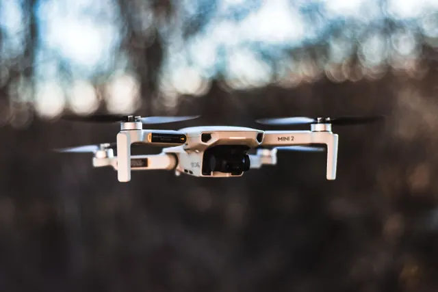 Pequeño dron volando en el interior de una vivienda junto a su estación de carga
