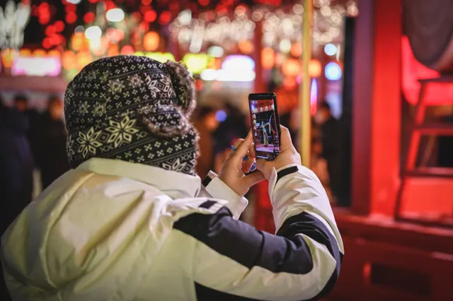 Persona consultando el programa de fiestas de un pueblo en la pantalla de su móvil