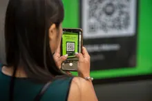 Teléfono móvil sobre una mesa junto a una entrada de papel y unos auriculares