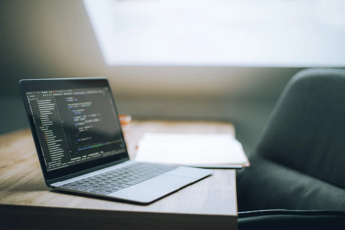 Un portátil con código de programación en la pantalla sobre una mesa
