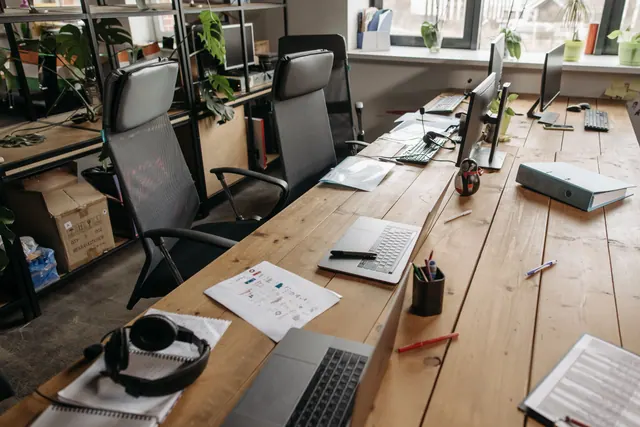 Portátiles y equipos informáticos sobre una mesa de oficina