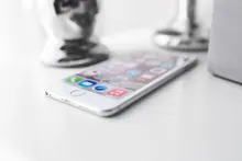 Un teléfono móvil sobre una mesa junto a objetos decorativos
