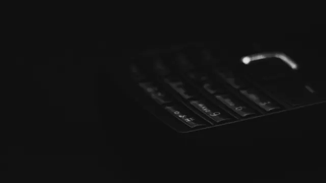 Teléfono móvil básico con teclado físico sobre una mesa de madera