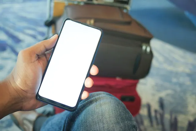 Persona sujetando un teléfono móvil en una sala de espera