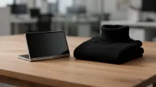 Tablet y jersey negro sobre mesa de madera en oficina