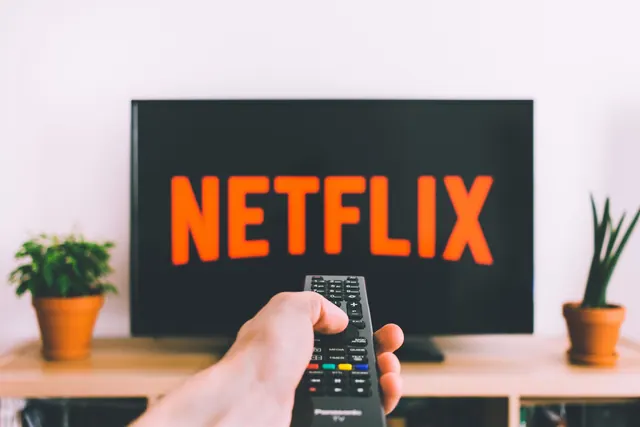 Persona en el sofá viendo una plataforma de streaming en el televisor