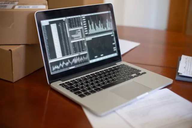 Portátil con gráficos de datos sobre una mesa de madera