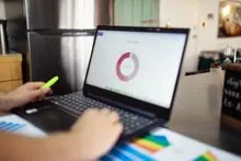 Una persona trabaja con un portátil mostrando un gráfico circular