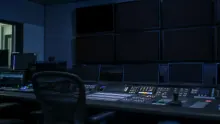 Sala de control con múltiples monitores y consola de edición de vídeo
