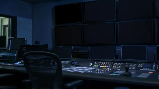Sala de control con múltiples monitores y consola de edición de vídeo