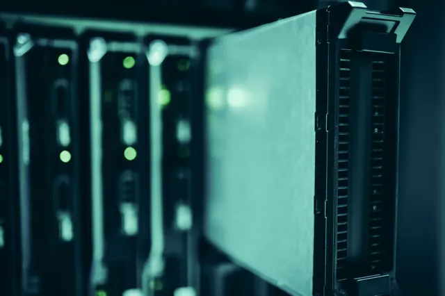Pasillo de un gran centro de datos con racks de servidores iluminados
