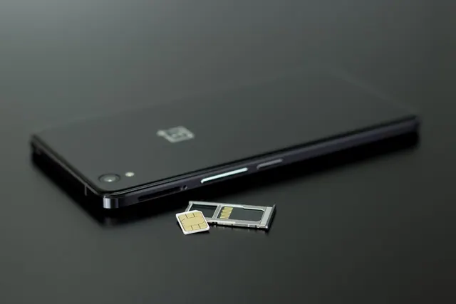 Tarjeta SIM junto a un smartphone, símbolo de la verificación de identidad basada en la red móvil
