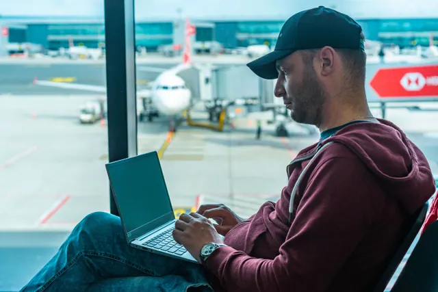 Pasajero usando un portátil conectado al WiFi durante un vuelo comercial