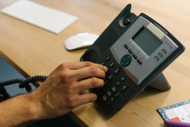 Teléfono móvil básico con teclado físico apoyado sobre una mesa