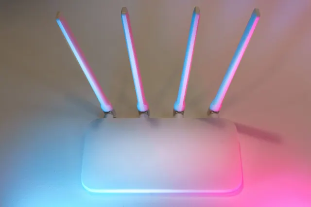 Un router wifi con cuatro antenas iluminado con luces de colores