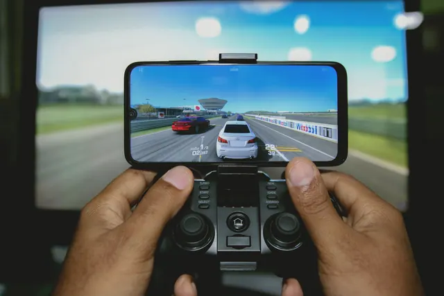 Mando de videojuegos junto a un teléfono móvil sobre una mesa