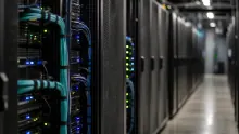 Interior de centro de datos con servidores y cables de red azules y cian iluminados