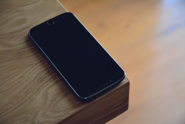 Primer plano de un teléfono móvil con pantalla de bordes muy estrechos sobre una mesa