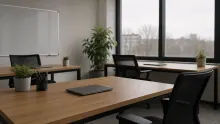 Oficina moderna con mesas de madera, sillas negras y plantas junto a ventanales