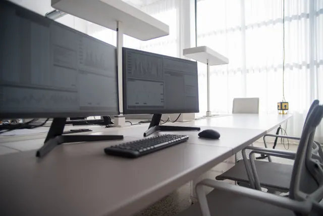 Monitores con gráficos financieros en una oficina vacía