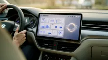 Persona al volante de un vehículo con pantalla táctil de infoentretenimiento