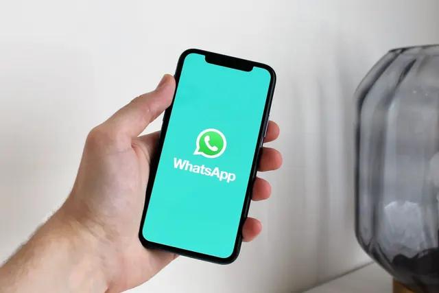 Persona escuchando un mensaje de voz en una app de mensajería en el móvil
