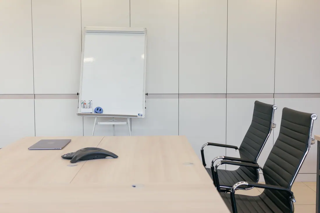 Sala de reuniones moderna y vacía en una oficina con pantalla y mesa de trabajo