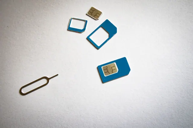 Tarjeta SIM junto a un teléfono móvil sobre una mesa