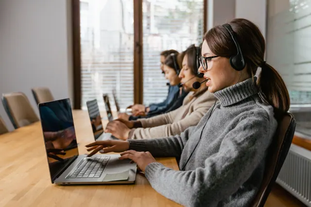 Equipo comercial trabajando con software de gestión de clientes en un portátil
