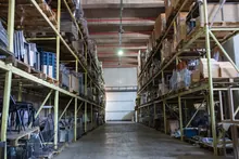 Pasillo de un almacén industrial con estanterías cargadas de mercancía