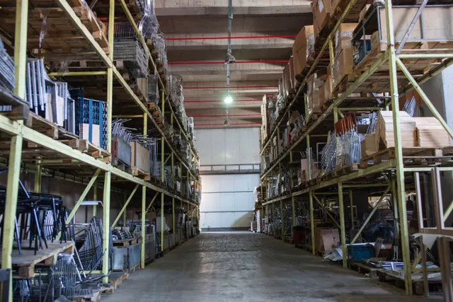 Pasillo de un almacén industrial con estanterías cargadas de mercancía