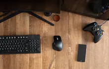 Mando de videojuegos sobre una mesa junto a un teclado y un monitor de ordenador