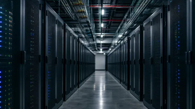 Pasillo de un centro de datos con servidores a ambos lados y luces LED indicadoras