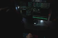 Pantalla con código de programación en un entorno oscuro que evoca la ciberseguridad