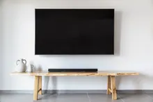 Televisor montado en la pared sobre una mesa de madera