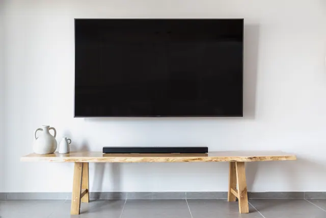 Televisor montado en la pared sobre una mesa de madera