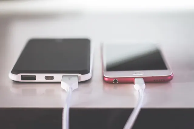 Teléfono móvil conectado a un cargador sobre una mesa