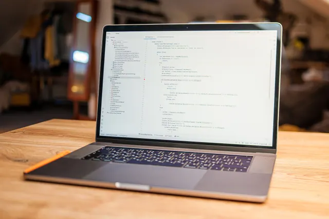 Portátil sobre una mesa mostrando líneas de código en un editor
