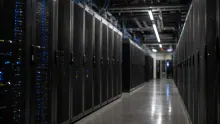 Pasillo de un centro de datos con filas de servidores negros iluminados