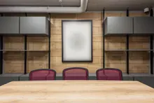 Sala de reuniones vacía con mesa de madera y sillas rojas