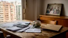 Escritorio de madera con documentos, calculadora y reloj despertador junto