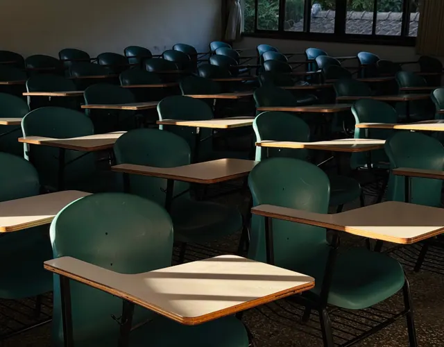 Aula vacía con sillas y pupitres individuales en fila