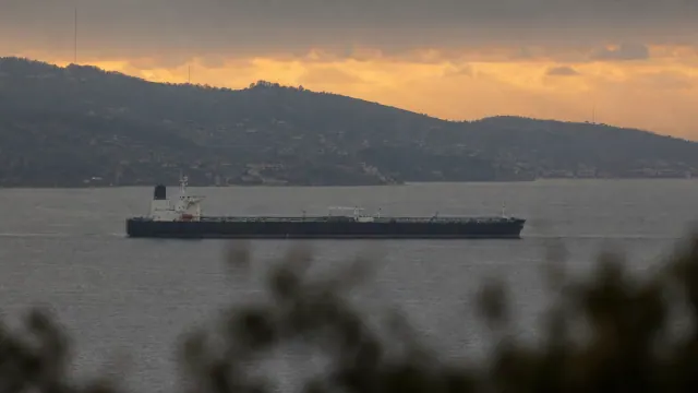 Petrolero fondeado en bahía al atardecer con montañas al fondo