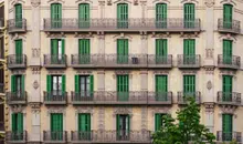 Fachada de un edificio clásico con balcones y persianas verdes