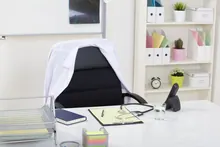 Despacho médico con una bata sobre la silla y un estetoscopio en la mesa