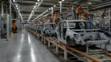 Línea de montaje de automóviles en una fábrica con brazos robóticos y carrocerías